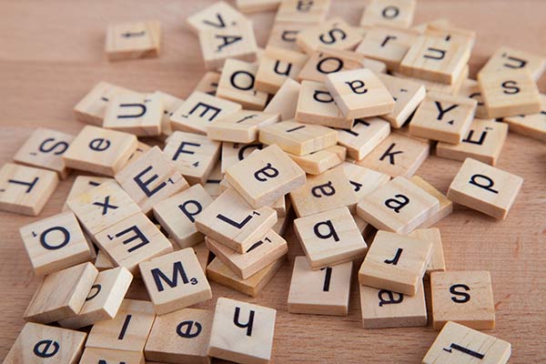 Wooden Scrabble letter blocks scattered across a table