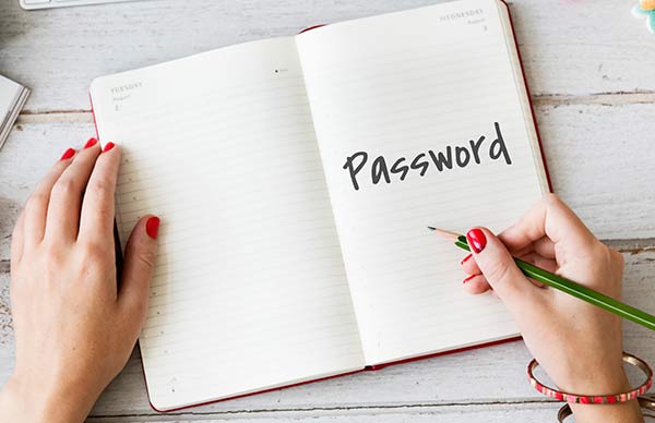 Woman writing her passwords in a journal. 